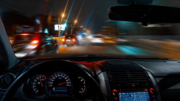 A dangerously blurry view of cars, streetlights, headlights through a car window at night; concept is night blindness